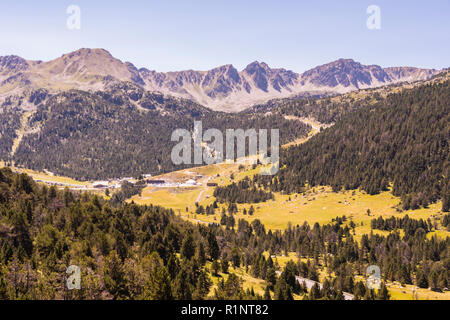 View of the peaks of the Pyrenees and a valley surrounded by green pine forests. Europe Andorra Stock Photo