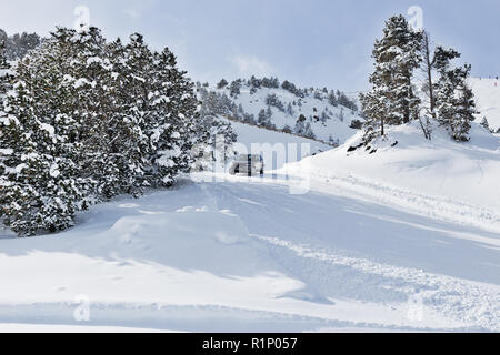 PYRENEES, ANDORRA - FEBRUARY 7, 2018: Test drive the Land Rover on a snow-covered road. Winter trail in the mountains, sunny winter day Stock Photo