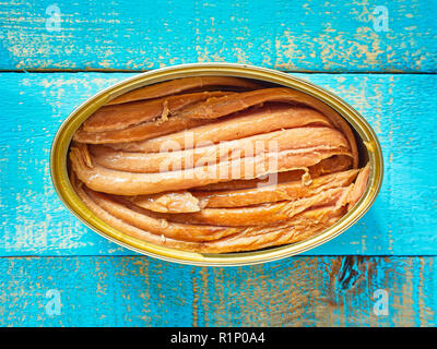 Can of Tuna in Oil. Canned Tuna fish over a Mediterranean blue wooden table background. Stock Photo