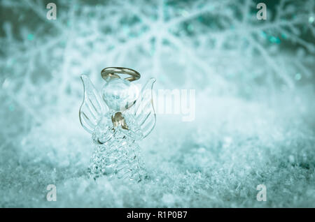 vitreous angel and simple white snowflake decoration in snowy background Stock Photo