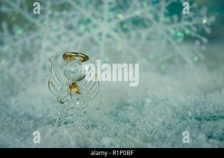 vitreous angel and simple white snowflake decoration in snowy background Stock Photo