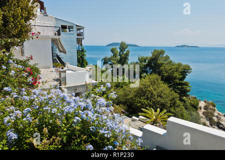 House with a view to Sporades islands surronouded by a lot of beautiful flowers at the old town of Skiathos, Greece Stock Photo