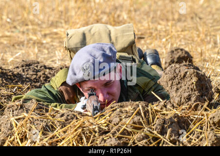 Second World War soldier re-enactment. Young British Army soldier laying prone with rifle. Looking through gunsight, gun sight. Weapon. Aiming Stock Photo