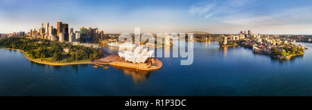 Wide calm Sydney harbour around city CBD high-rise towers and the Sydney Harbour bridge connecting The Rocks with North Shore. Stock Photo