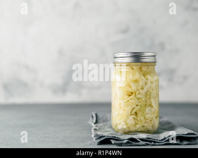 Sauerkraut in glass mason jar. Pickling cabbage at home on table. The best natural probiotic. Homemade kraut., copy space for text Stock Photo