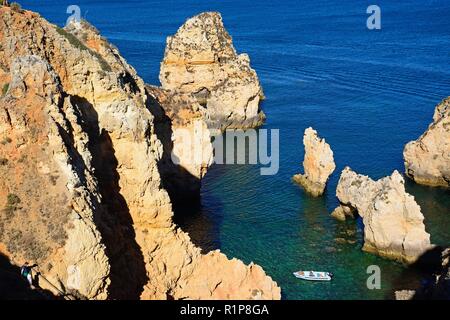 Elevated view of the cliffs with small boats in the bay, Ponta da Piedade, Lagos, Algarve, Portugal, Europe. Stock Photo