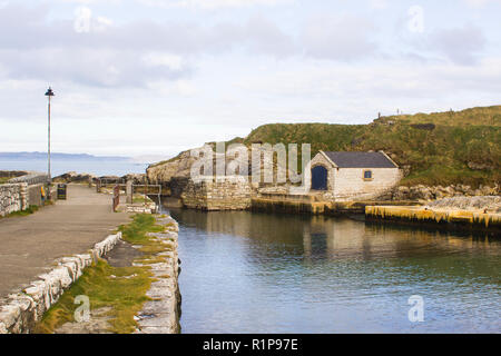 The small harbor at Ballintoy on the North Antrim Coast of Northern Ireland with its ancient stone built boathouse on a day in spring Stock Photo