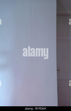 simple sheets of plain wallpaper on wall with join showing near a doorway Stock Photo