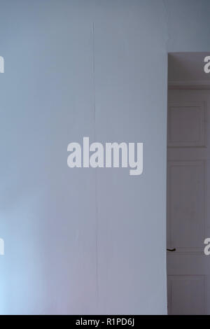 simple sheets of plain wallpaper on wall with join showing near a doorway Stock Photo