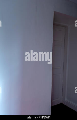 simple sheets of plain wallpaper on wall with join showing near a doorway Stock Photo
