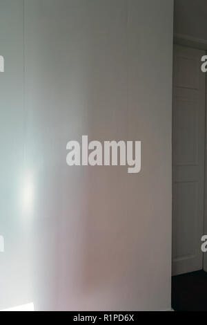 simple sheets of plain wallpaper on wall with join showing near a doorway Stock Photo