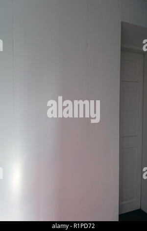simple sheets of plain wallpaper on wall with join showing near a doorway Stock Photo