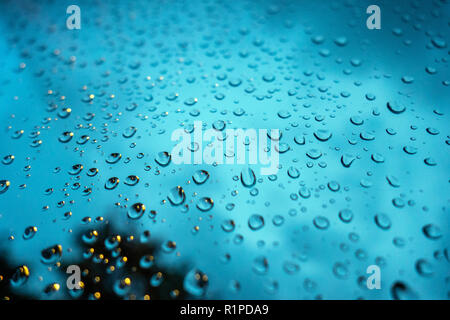 very closeup photograph of raindrops on glass window with dark sky in the background Stock Photo