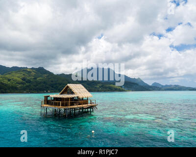 Overwater bungalow of black pearl farmers. Blue azure turquoise lagoon with corals. Raiatea island near Tahiti, Society islands, French Polynesia. Stock Photo