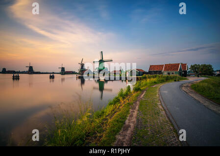 Sunset above farm houses and windmills of Zaanse Schans in the Netherlands Stock Photo