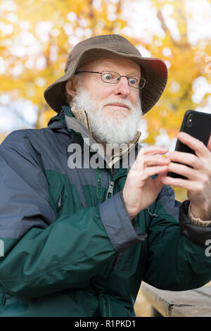 Senior man outdoors using a smartphone Stock Photo