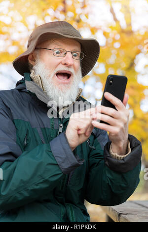 Senior man outdoors using a smartphone Stock Photo