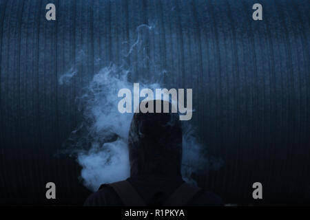 Man in smoke on the dark background Stock Photo