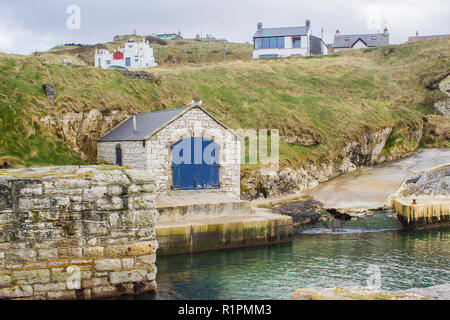 The small harbor at Ballintoy on the North Antrim Coast of Northern Ireland with its ancient stone built boathouse on a day in spring Stock Photo