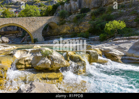 idyllic river with small fall and old bridge in the Provence, France, Gorges de la Méouge Stock Photo