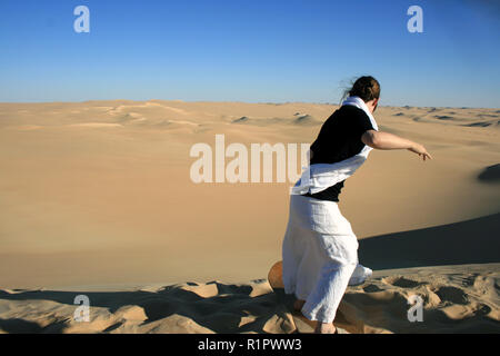 Sandboarding launch from top of dune in Sahara desert, near Siwa, Egypt Stock Photo