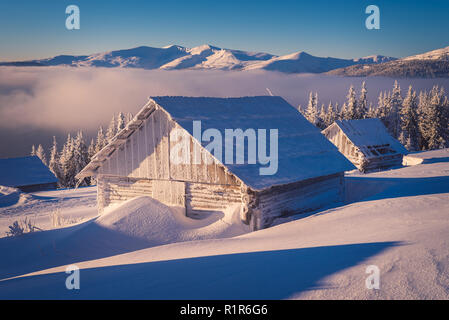Winter landscape with wooden house in the frost. Mountain village of shepherds. Carpathians, Ukraine, Europe Stock Photo