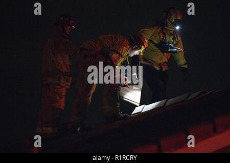 Rialto, CA, USA. 14th Nov, 2018. At 9 pm,  a fast-moving brush fire breaks out, burning 20 acres in the first three minutes. Rialto Fire Department checks the roof of a home on Amberwood Court. Credit: Chris Rusanowsky/ZUMA Wire/Alamy Live News Stock Photo