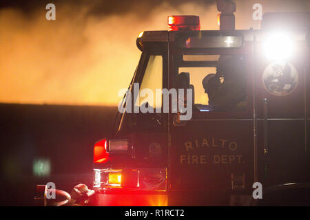 Rialto, CA, USA. 14th Nov, 2018. At 9 pm,  a fast-moving brush fire breaks out, burning 20 acres in the first three minutes. Rialto Fire Department trucks stage near Amberwood Court as they take control of the brush fire. Credit: Chris Rusanowsky/ZUMA Wire/Alamy Live News Stock Photo