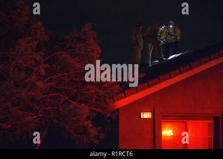 Rialto, CA, USA. 14th Nov, 2018. At 9 pm,  a fast-moving brush fire breaks out, burning 20 acres in the first three minutes. Rialto Fire Department checks the roof of a home on Amberwood Court. Credit: Chris Rusanowsky/ZUMA Wire/Alamy Live News Stock Photo