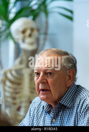 14 November 2018, Hessen, Frankfurt/Main: The American paleoanthropologist and discoverer of the skeleton 'Lucy', Donald C. Johanson, speaks to journalists during a press conference at the Senckenberg Museum. The paleoanthropologist discovered the Australopithecus afarensis skeletal remains 44 years ago in Ethiopia. The skeleton 'Lucy' was long regarded as the oldest evidence of the upright gait of our ancestors. The skeleton in the background doesn't represent Lucy. Photo: Silas Stein/dpa Stock Photo