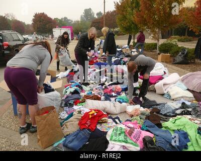 Chico, USA. 13th Nov, 2018. In front of an emergency shelter in Chico, a neighbouring town of Paradise, clothing donations are made after they have lost their belongings through the forest fire, the so-called 'camp' fire. 50,000 people had to leave the danger zone, more than 1300 are scattered in emergency shelters, in many places there is no mobile phone reception. It's chaos. (to dpa 'Paradise as hell on earth - 'Will create a new church' of 14.11.2018) Credit: Barbara Munker/dpa/Alamy Live News Stock Photo