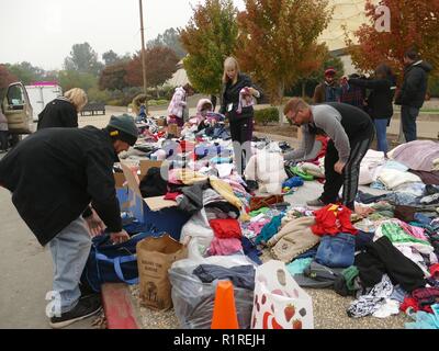 Chico, USA. 13th Nov, 2018. In front of an emergency shelter in Chico, a neighbouring town of Paradise, clothing donations are made after they have lost their belongings through the forest fire, the so-called 'camp' fire. 50,000 people had to leave the danger zone, more than 1300 are scattered in emergency shelters, in many places there is no mobile phone reception. It's chaos. (to dpa 'Paradise as hell on earth - 'Will create a new church' of 14.11.2018) Credit: Barbara Munker/dpa/Alamy Live News Stock Photo