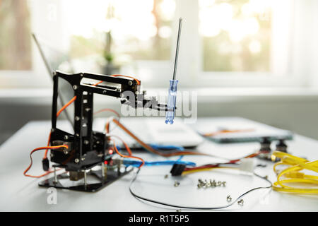 robotics industry - robot arm and laptop on the table Stock Photo