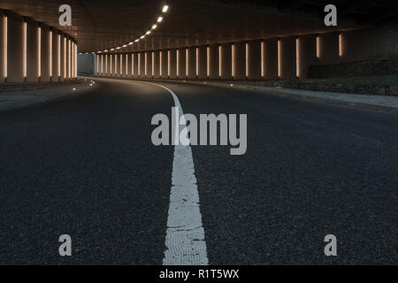 Curved lit road tunnel Stock Photo