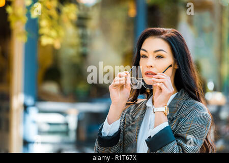 beautiful woman in autumnal jacket wearing glasses on street Stock Photo