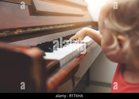music education - child pushing piano keys Stock Photo