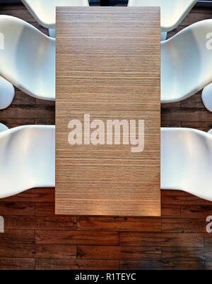 Top view from above on a empty office wooden table, plastic chairs and hardwood floor Stock Photo