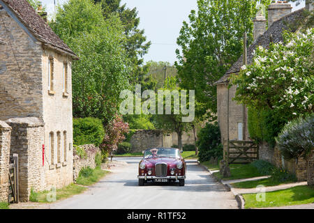 Motorist driving 1961 British made Alvis TD21 drophead ooupe classic car on country lane, Asthall village, The Cotswolds England Stock Photo