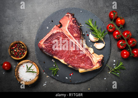 T-bone beef steak on black with spices.  Stock Photo