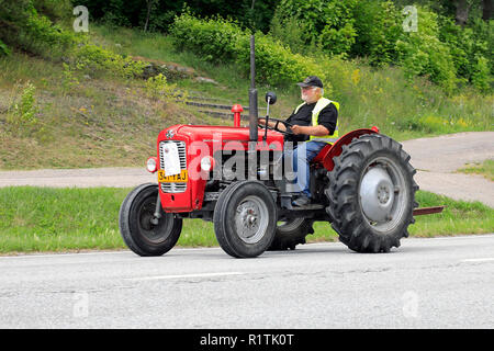 Classic Massey-Ferguson 35 tractor and driver on Kimito Tractorkavalkad, Tractor Cavalcade, an annual tractor show in Kimito, Finland - July 7, 2018. Stock Photo