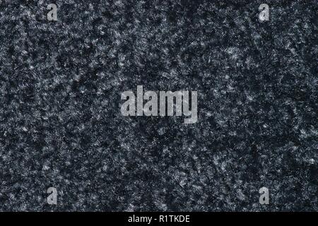 Texture of a swatch of thick smoky black floor mat with light-colored gray flecks in it. Stock Photo