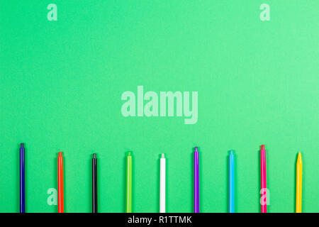 Set of colored pens on green background Stock Photo