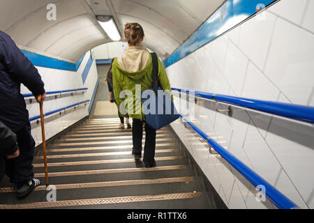 Tube commuters time, Young woman walking down on stairs to the tube station Stock Photo