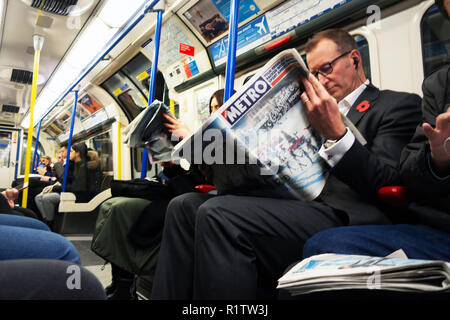 Tube commuters time, commuters reading on the London Underground Tube Stock Photo