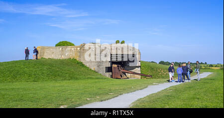 Tourists with guide visiting bunker of the Batterie Le Chaos, part of the Atlantikwall at Longues-sur-Mer, Normandy, France Stock Photo