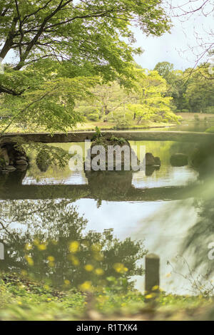 japanese Togetsu Stone bridge on the pond of Rikugien Park in Bunkyo district, north of Tokyo. The park was created at the beginning of the 18th centu Stock Photo