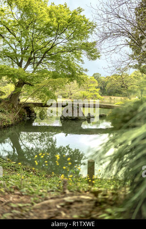 japanese Togetsu Stone bridge on the pond of Rikugien Park in Bunkyo district, north of Tokyo. The park was created at the beginning of the 18th centu Stock Photo