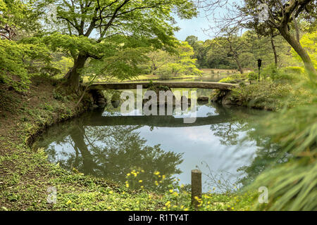 japanese Togetsu Stone bridge on the pond of Rikugien Park in Bunkyo district, north of Tokyo. The park was created at the beginning of the 18th centu Stock Photo