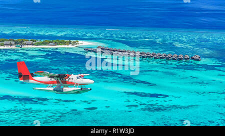 Aerial view of a seaplane approaching island in the Maldives. Maldives beach from birds eye view. Aerial view on Maldives island, atolls and blue sea