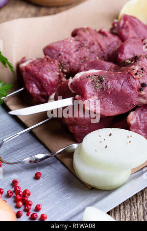 Raw fresh beef skewers,butchery uncooked chopped meat and cooking ingredients on wooden table Stock Photo